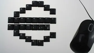 Tasten einer Tastatur bilden das Euro-Zeichen neben einer Maus.