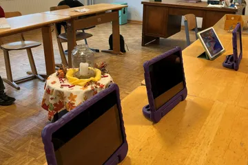 Ein Klassenraum mit Schultischen und aufgestellten Tablets