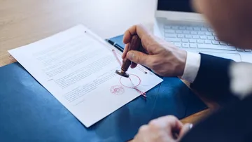 Jemand stempelt ein wichtiges Dokument.