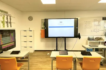 Ein Klassenraum des Gymnasium mit einem Smartboard und Sitzplätzen