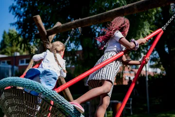 Zwei Kinder Schaukeln im Schulgarten
